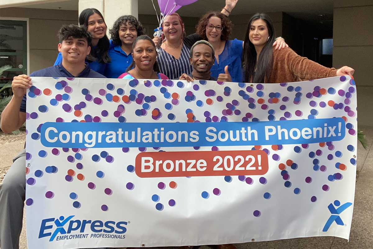 Express South Phoenix recruitment team holding sign celebrating award. 