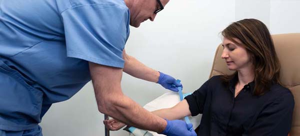 Vladimir Alexeyenko prepares a patient to receive an IV infusion during an appointment at his midtown office